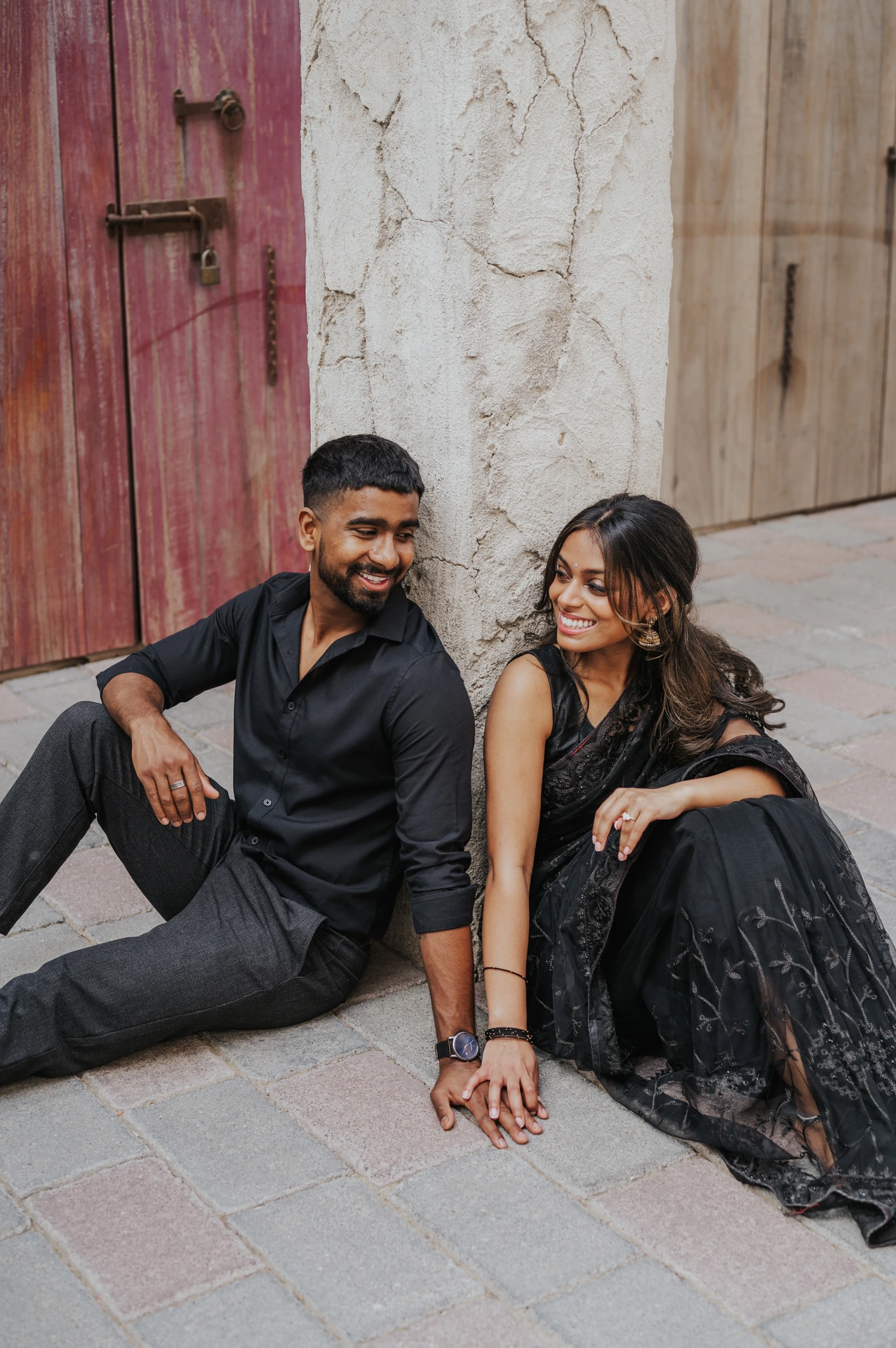 Couple in matching tones sitting in heritage district during engagement shoot