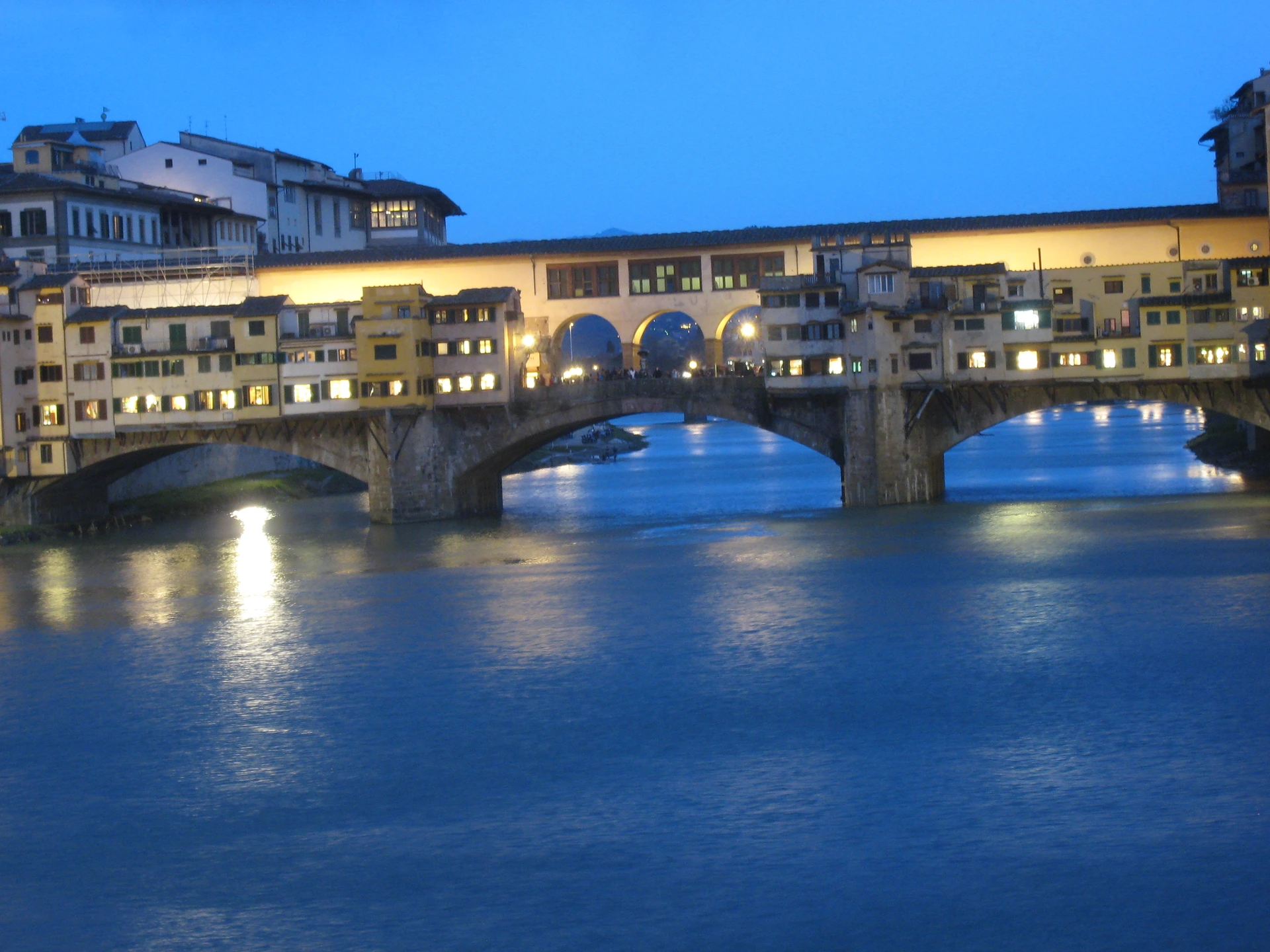 Illuminated Ponte Vecchio reflected in the Arno at blue hour from Ponte Santa Trinita