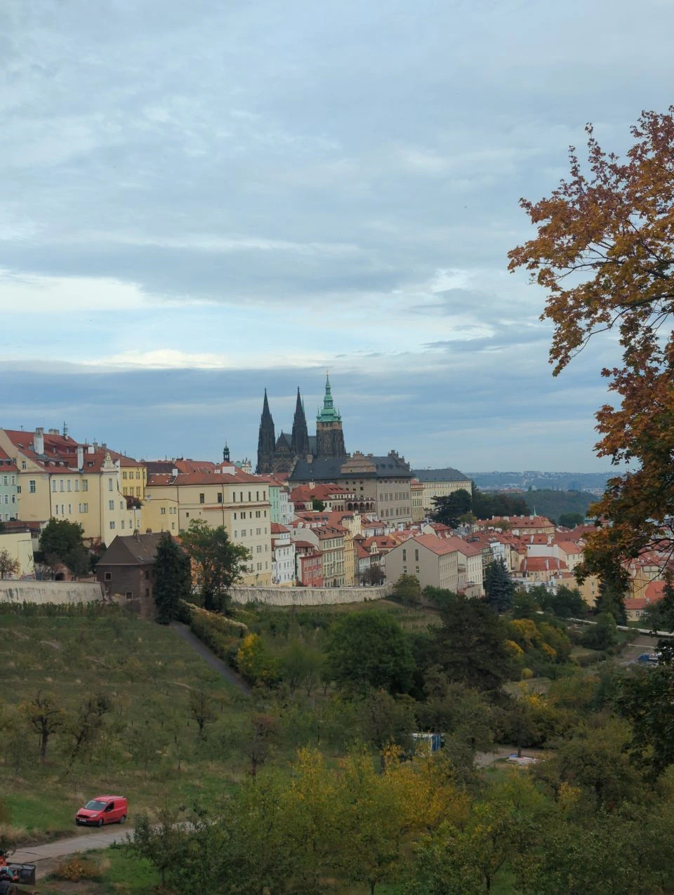 Prague Castle rises beyond green Strahov paths and colourful rooftops on a hilltop photo walk.