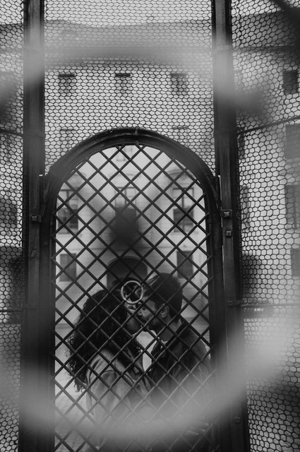 Prague anniversary photoshoot: black and white portrait through the decorative gate. Black and white portrait through the decorative gate during an anniversary couple photoshoot in Prague.