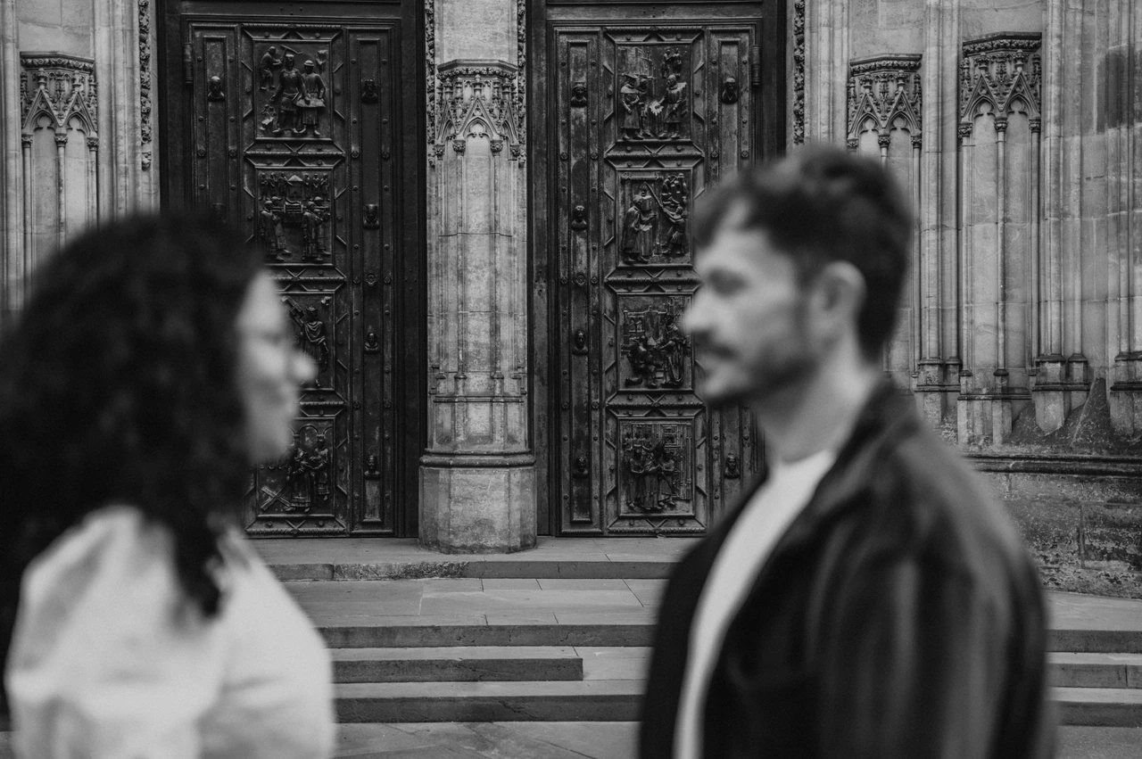 Prague anniversary photoshoot: black and white soft-focus portrait beside the cathedral entrance. Black and white soft-focus portrait beside the cathedral entrance during an anniversary couple photoshoot in Prague.