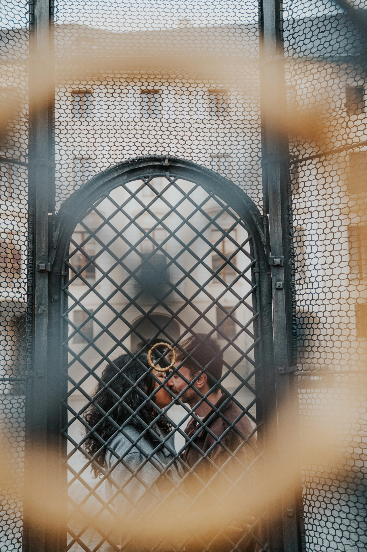 Couple seen through a decorative gate near the castle during an anniversary couple photoshoot in Prague.