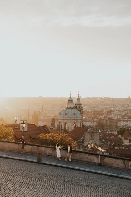 Prague anniversary photoshoot: couple standing close by the viewpoint wall above Prague. Couple standing close by the viewpoint wall above Prague during an anniversary couple photoshoot in Prague.