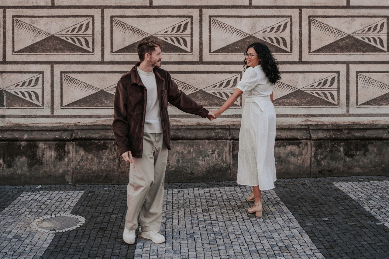 Prague anniversary photoshoot: couple turning towards each other beside the patterned wall. Couple turning towards each other beside the patterned wall during an anniversary couple photoshoot in Prague.
