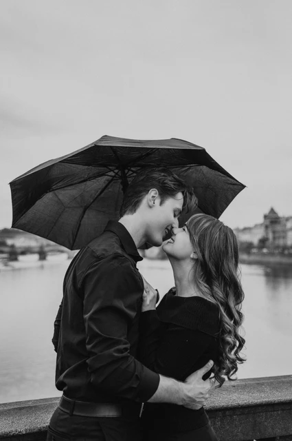Prague couple photoshoot: black and white kiss beneath the umbrella. Black and white kiss beneath the umbrella during a couple photoshoot in Prague.