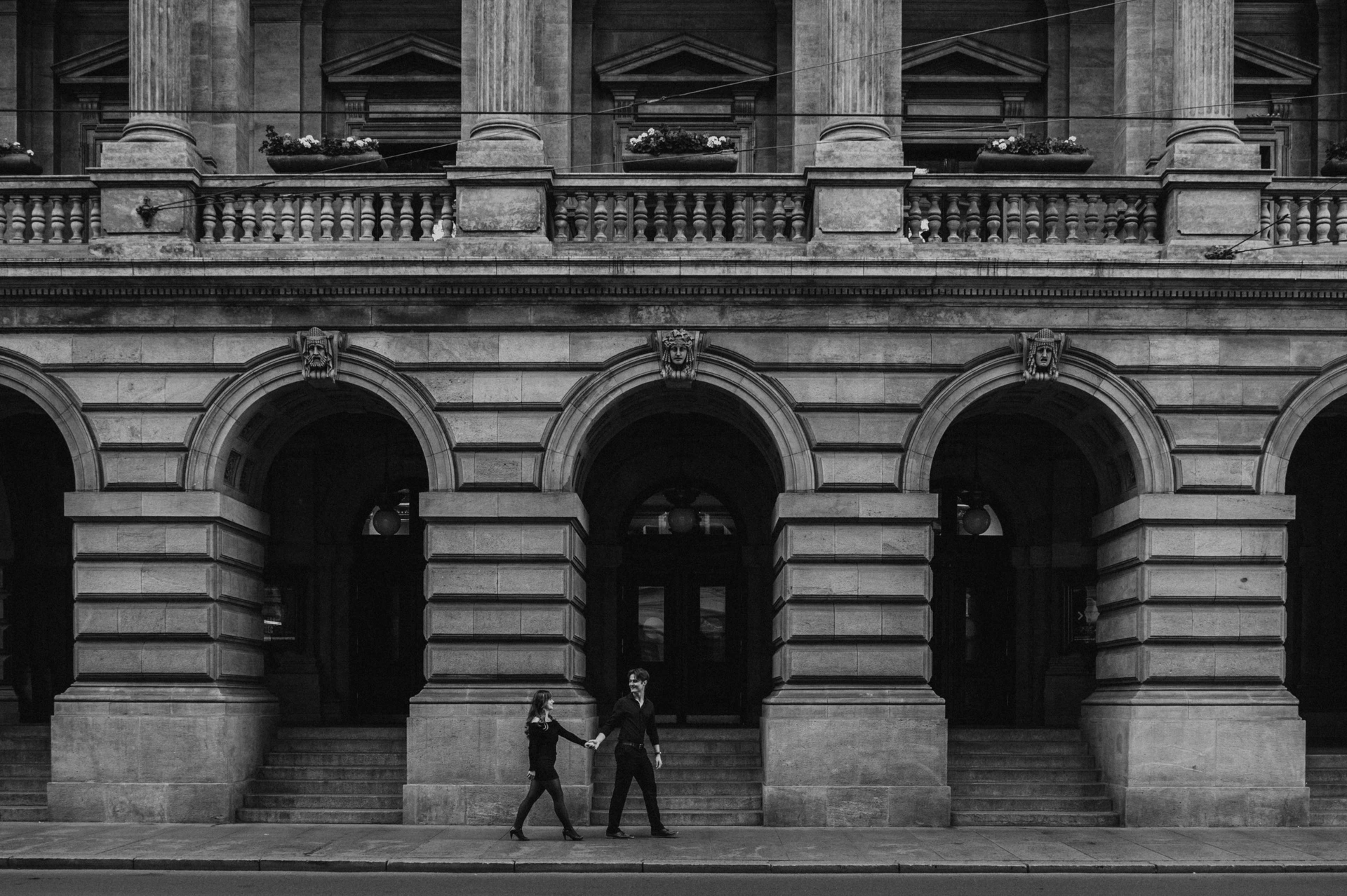 Black and white portrait beneath the National Theatre arches during a couple photoshoot in Prague.