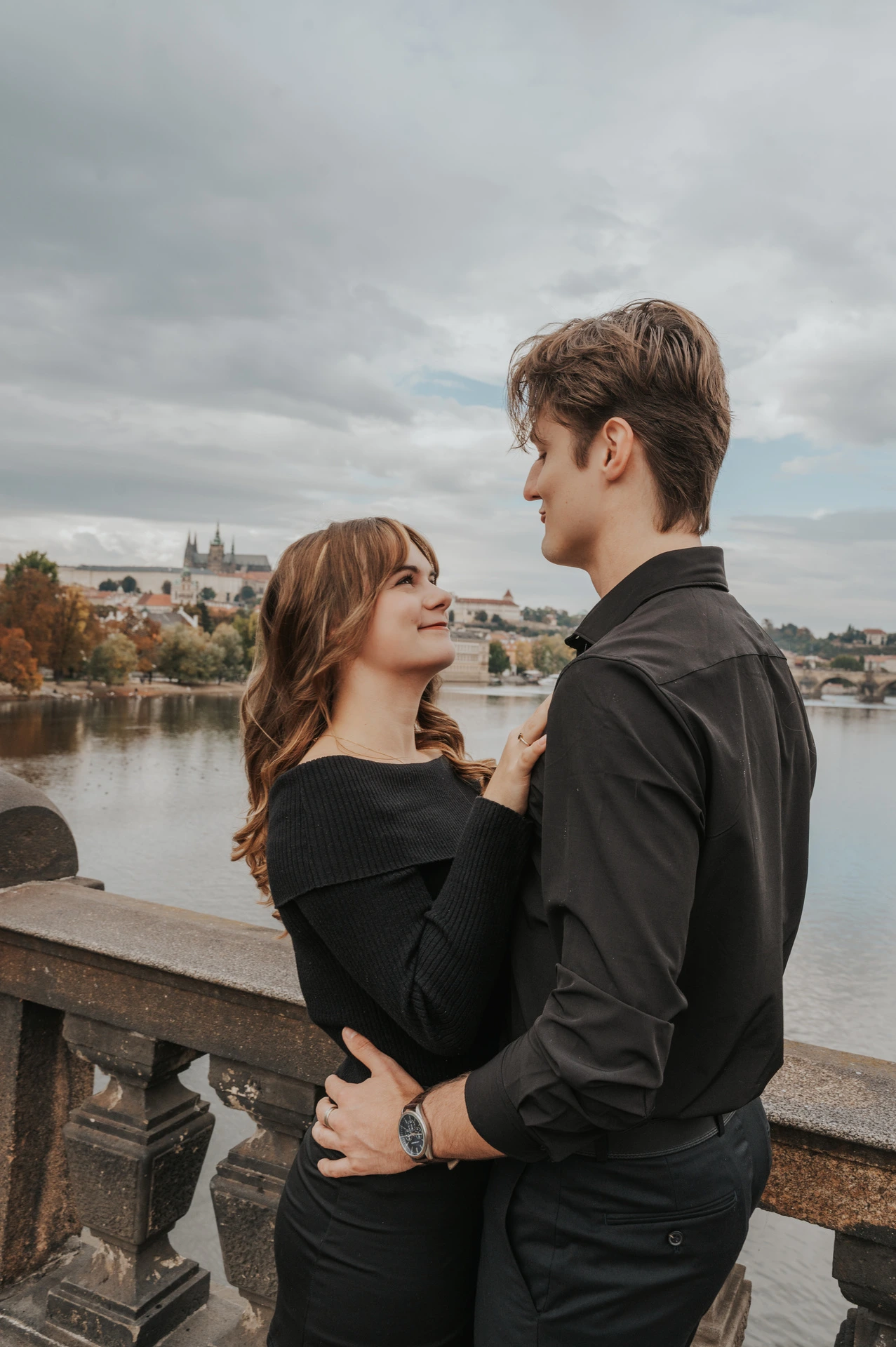Couple embracing beside the stone balustrade during a couple photoshoot in Prague.