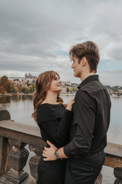 Prague couple photoshoot: couple embracing beside the stone balustrade. Couple embracing beside the stone balustrade during a couple photoshoot in Prague.