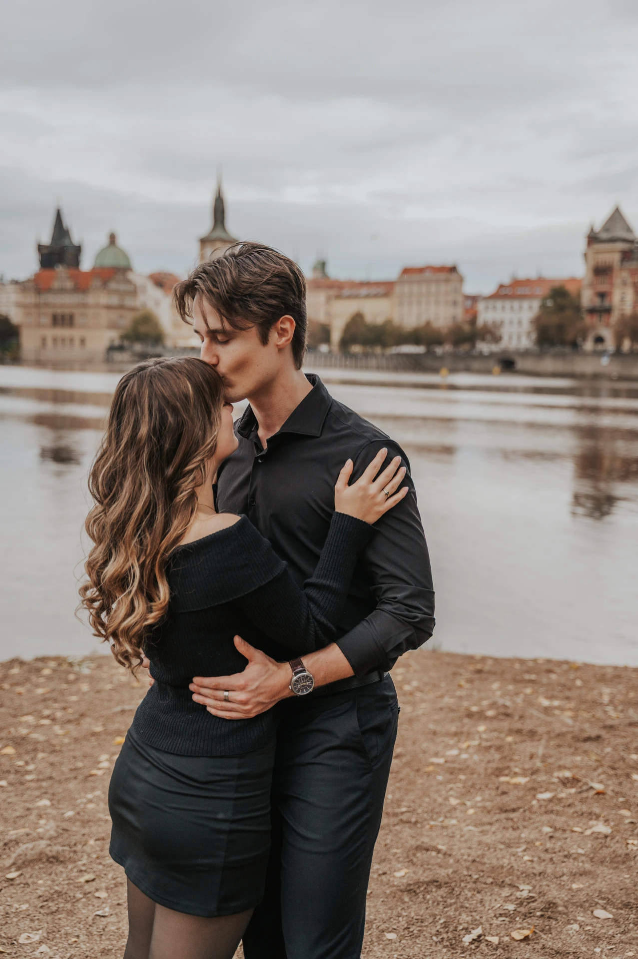 Couple sharing a kiss beside the water on Shooter’s Island during a couple photoshoot in Prague.