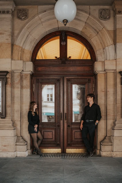 Prague couple photoshoot: couple smiling beneath the theatre entrance lamp. Couple smiling beneath the theatre entrance lamp during a couple photoshoot in Prague.