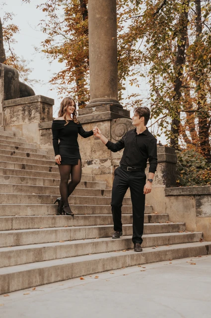 Couple walking down the stone steps towards Shooter’s Island during a couple photoshoot in Prague.