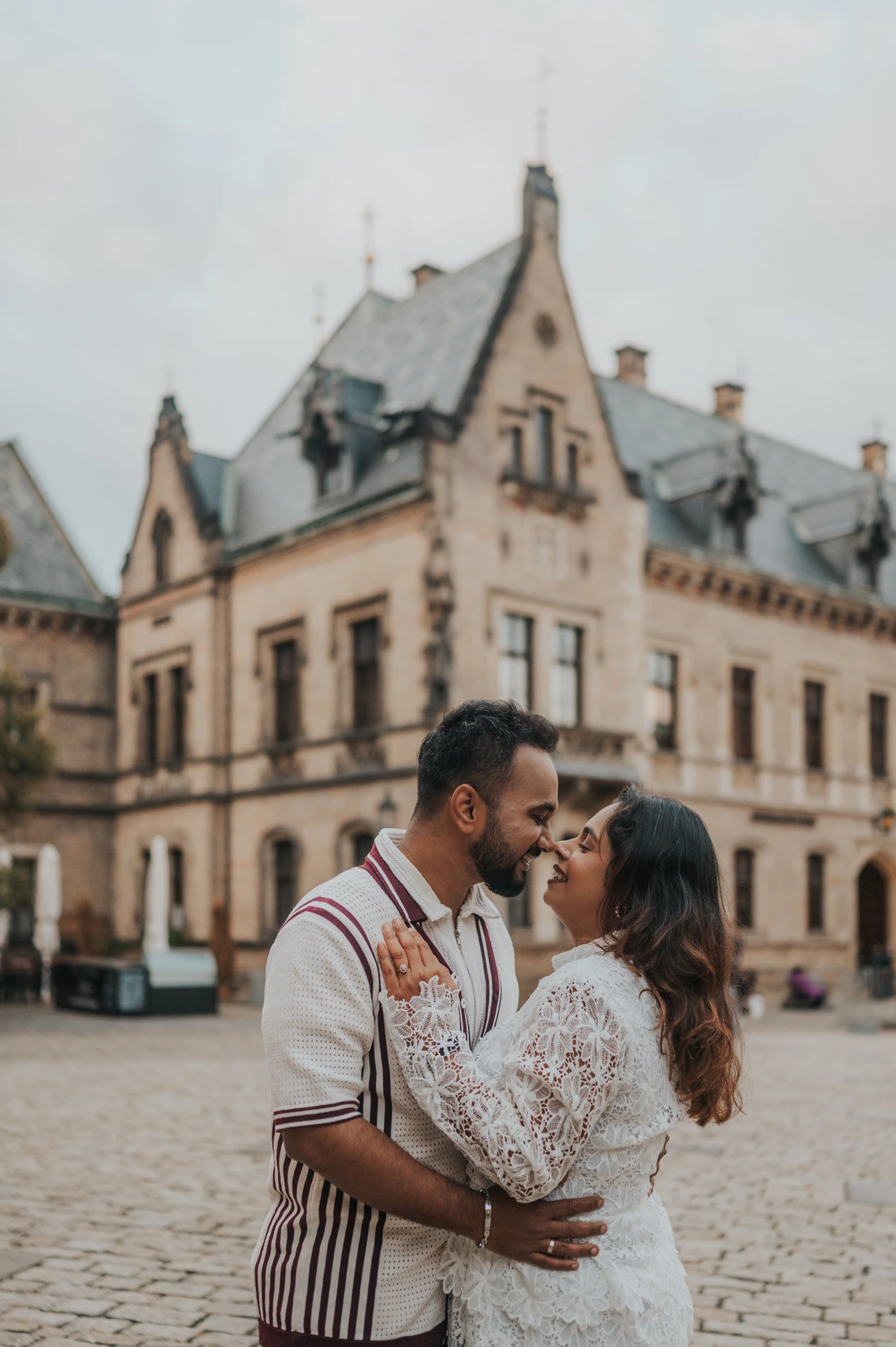 Close portrait of the couple kissing in a cobbled courtyard during their couple photoshoot at Prague Castle.