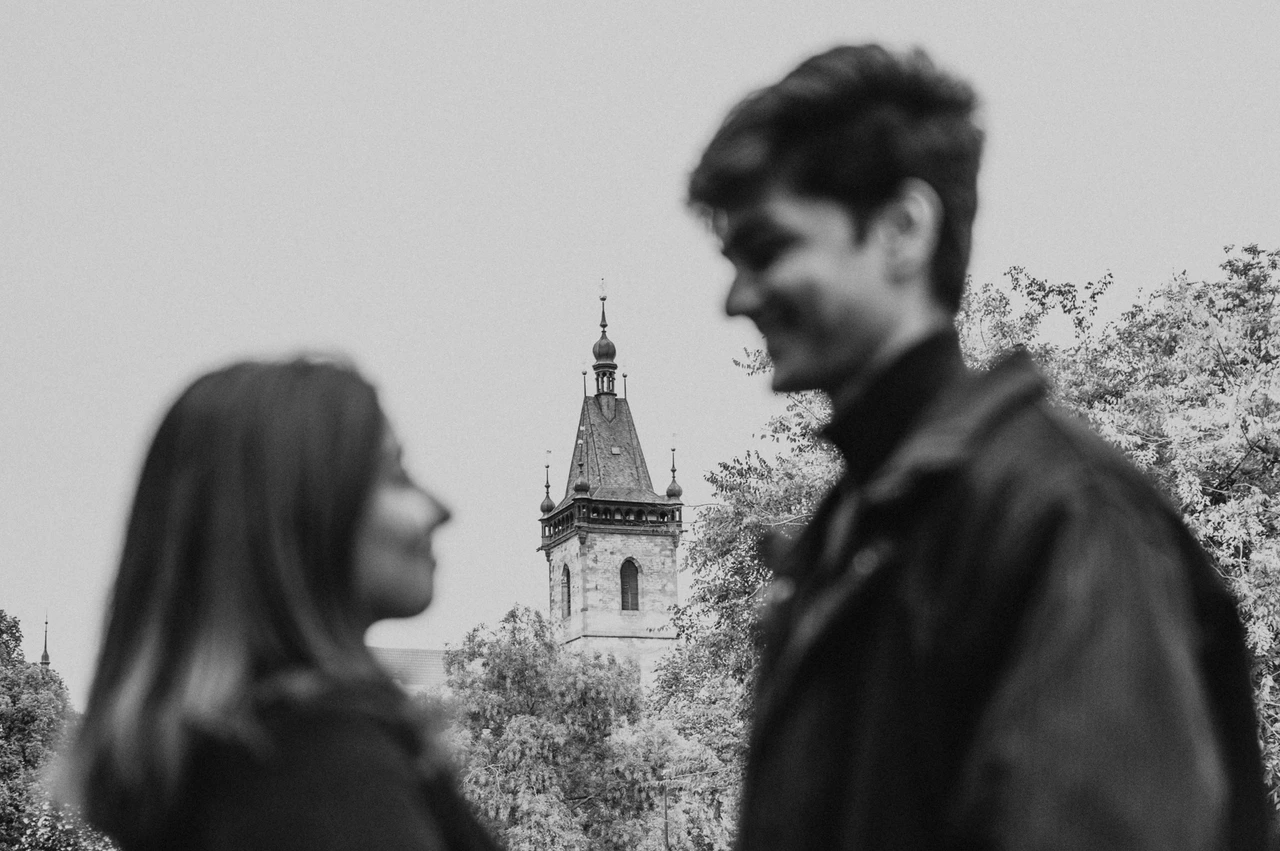Prague couple photoshoot: a black-and-white smile in the park Black-and-white close portrait of the couple facing each other with the man smiling during their Prague couple photoshoot.
