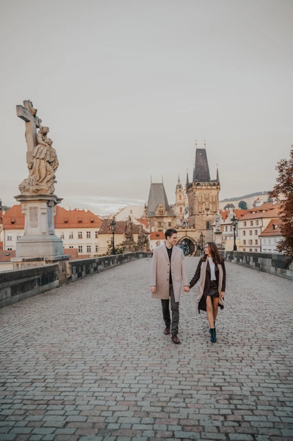 A walk across Charles Bridge Wide view across the cobbles of Charles Bridge as the couple walk together for their Prague engagement photoshoot