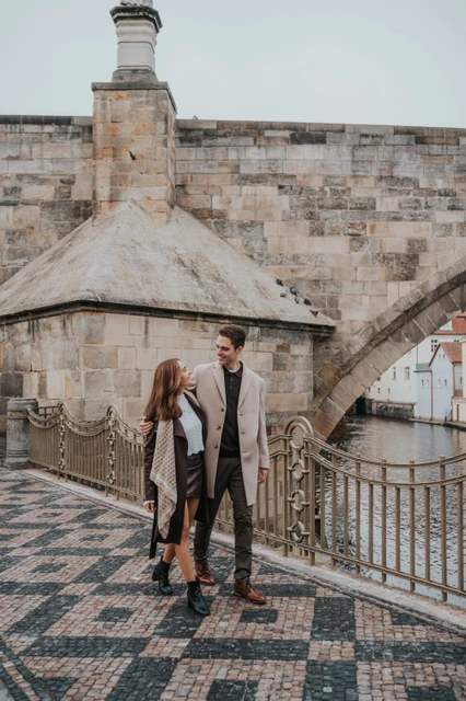 Patterned paving beneath Charles Bridge Couple holding hands on patterned paving beneath Charles Bridge during their engagement photoshoot in Prague