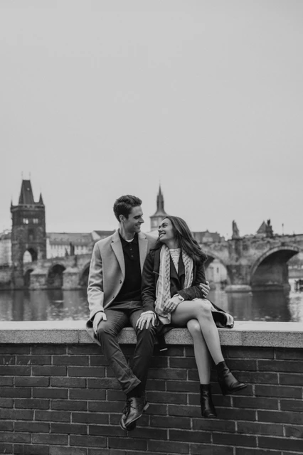 By the Vltava in black and white Black and white portrait of the couple sitting by the Vltava during their Prague engagement photoshoot