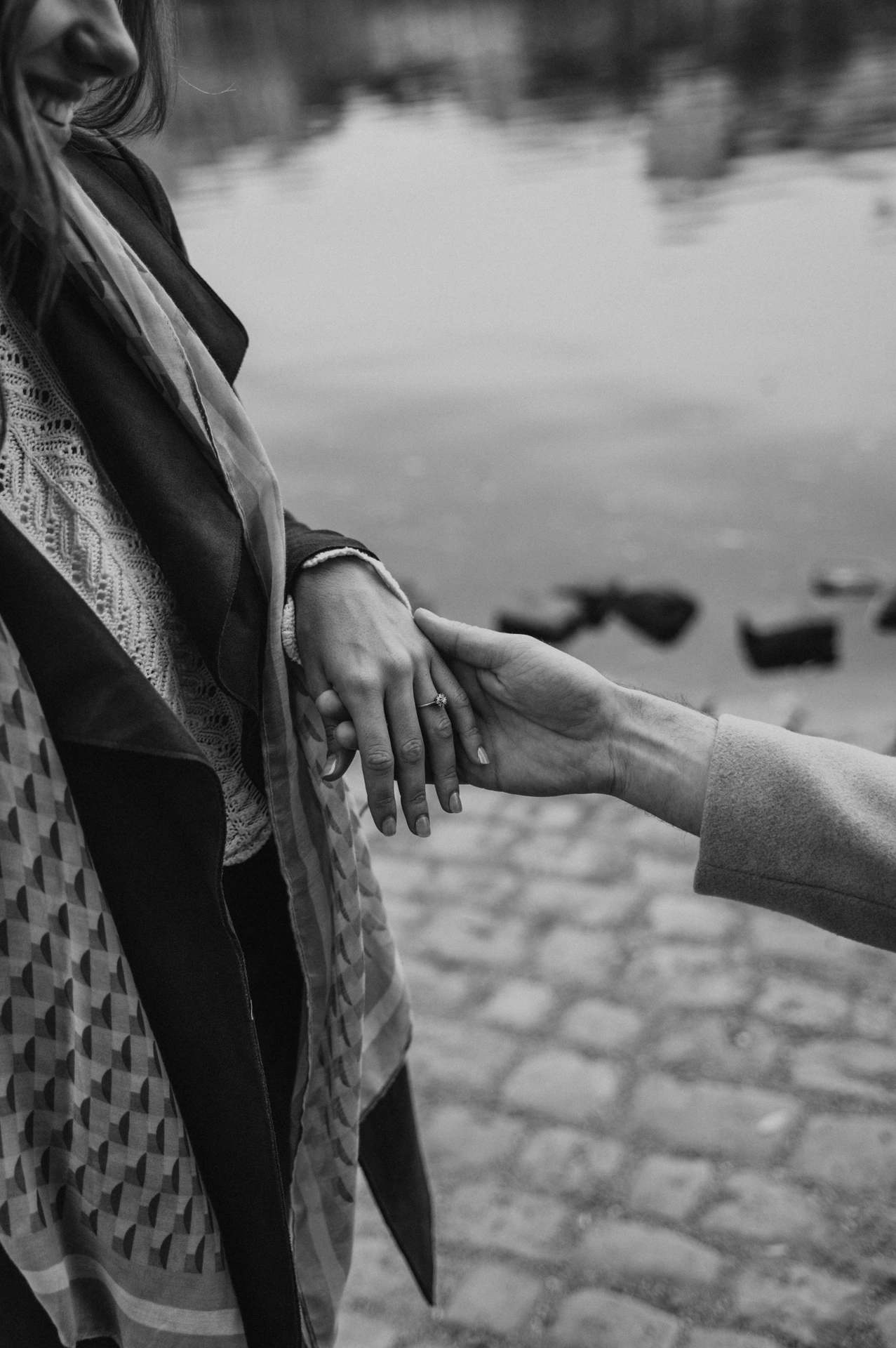 Black and white detail of the engagement ring and the couple's hands during their Prague proposal photoshoot