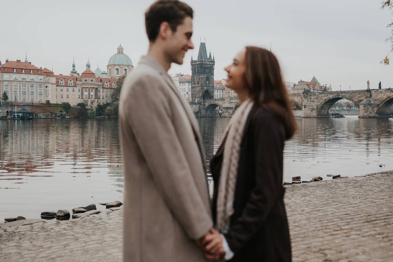An engagement portrait beside the river Close landscape portrait of the couple beside the Vltava during their Prague engagement photoshoot