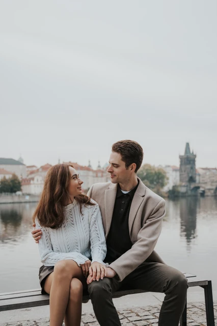 A quiet bench beside the Vltava Engaged couple relaxing on a bench beside the Vltava during their engagement photoshoot in Prague
