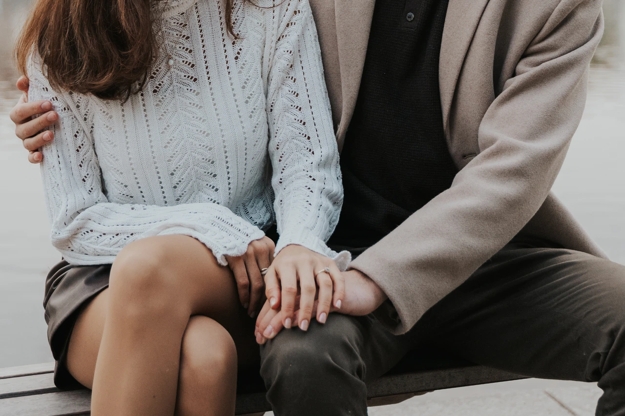 Ring detail after the Prague proposal photoshoot Close detail of the couple's hands and engagement ring on a riverside bench after their Prague proposal photoshoot