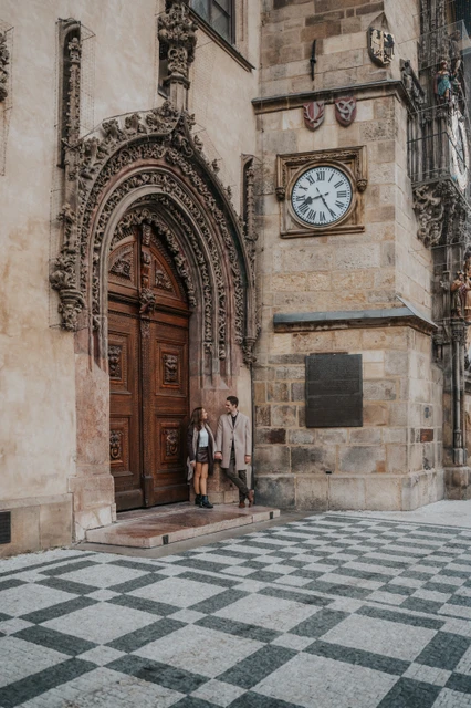 Engagement photoshoot at the Old Town Hall Couple standing beside a Gothic doorway at the Old Town Hall during their Prague engagement photoshoot