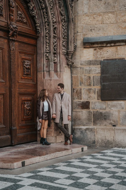 A portrait by an Old Town doorway Couple standing at an ornate doorway in Prague Old Town during their engagement photoshoot
