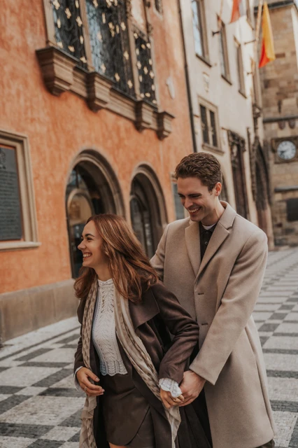 A street-side embrace in Prague Old Town Couple looking towards the street while embracing during their Prague Old Town engagement photoshoot