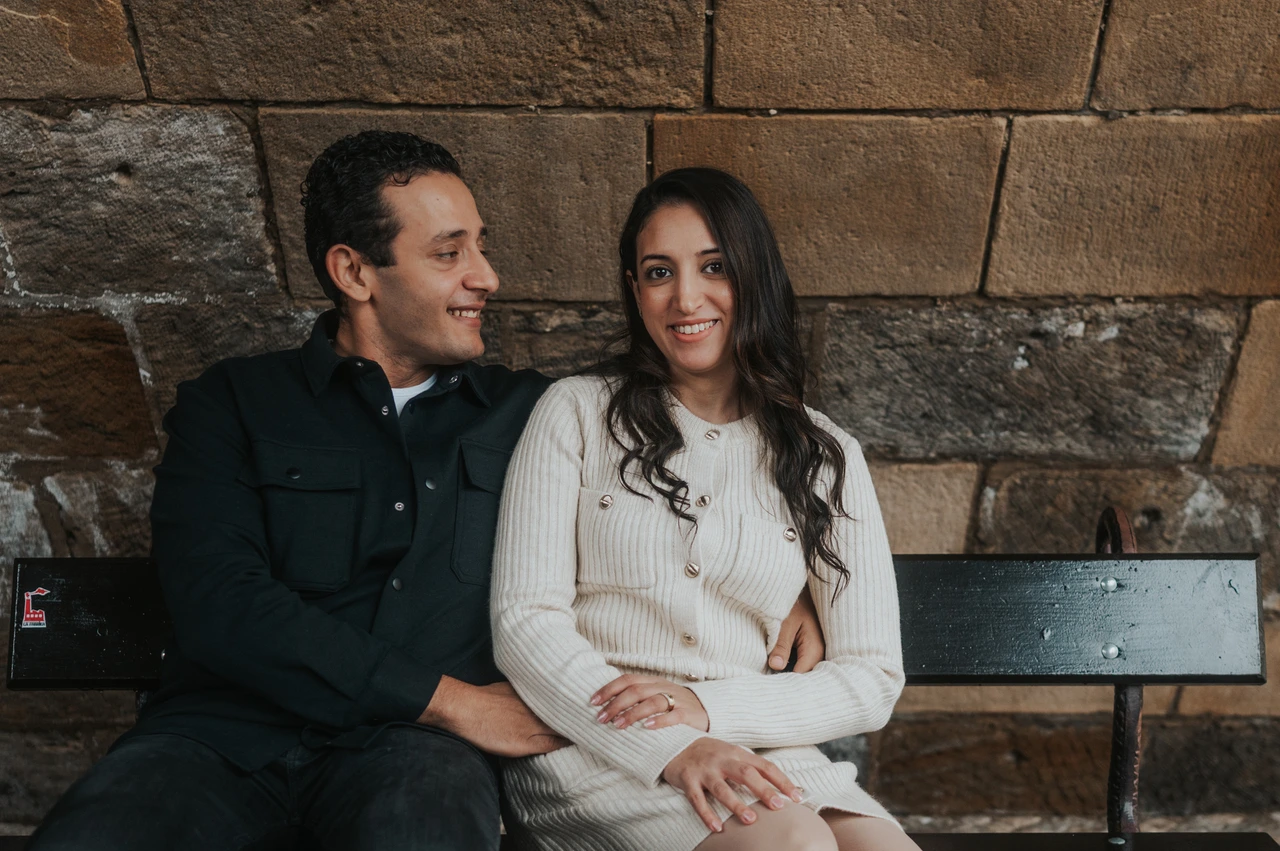 Prague family photoshoot: a close smile on the bench under the bridge Close portrait of the parents sharing a smile on the sheltered bench during their Prague family photoshoot.