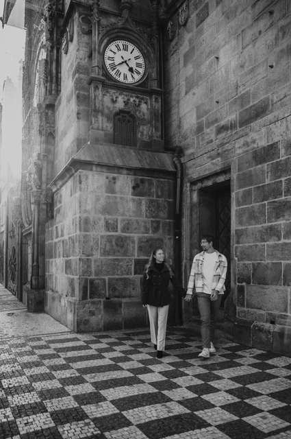 Prague couple photoshoot: black and white portrait under the small Old Town clock. Black and white portrait under the small Old Town clock during a couple photoshoot in Prague.