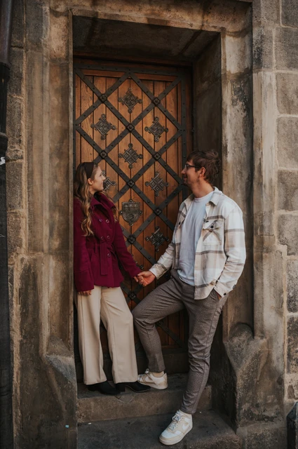 Prague couple photoshoot: couple smiling together beside the patterned doorway. Couple smiling together beside the patterned doorway during a couple photoshoot in Prague.
