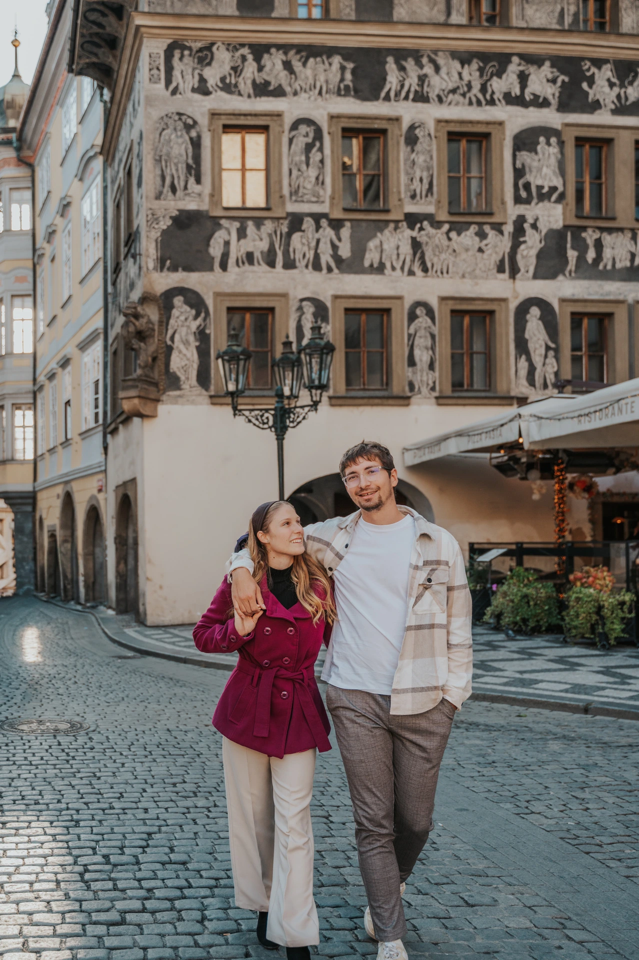 Couple smiling together in the Old Town street during a couple photoshoot in Prague.