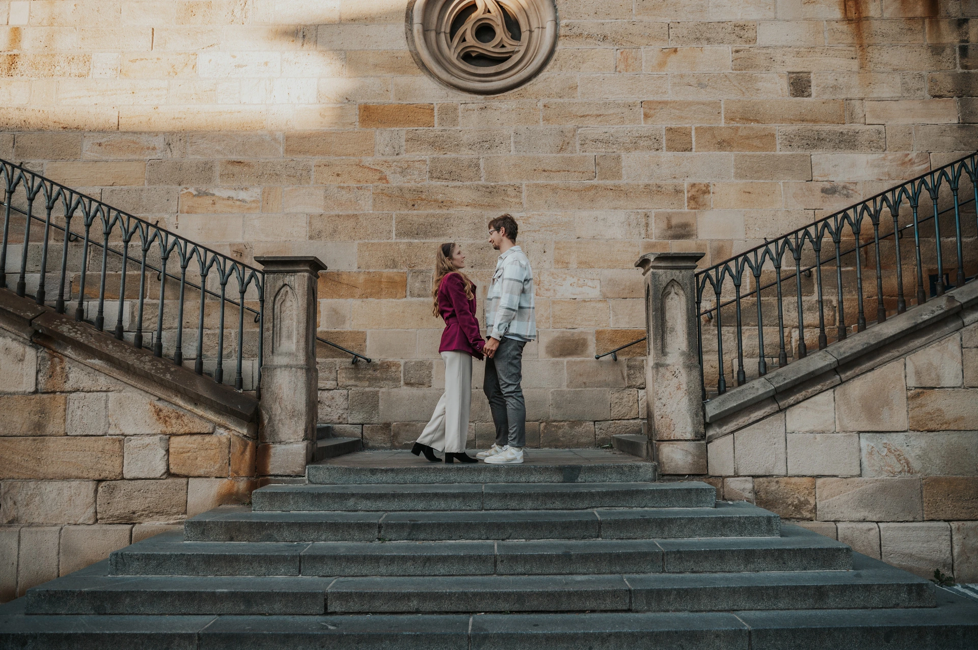 Prague couple photoshoot: couple standing together on the stone Kampa staircase. Couple standing together on the stone Kampa staircase during a couple photoshoot in Prague.