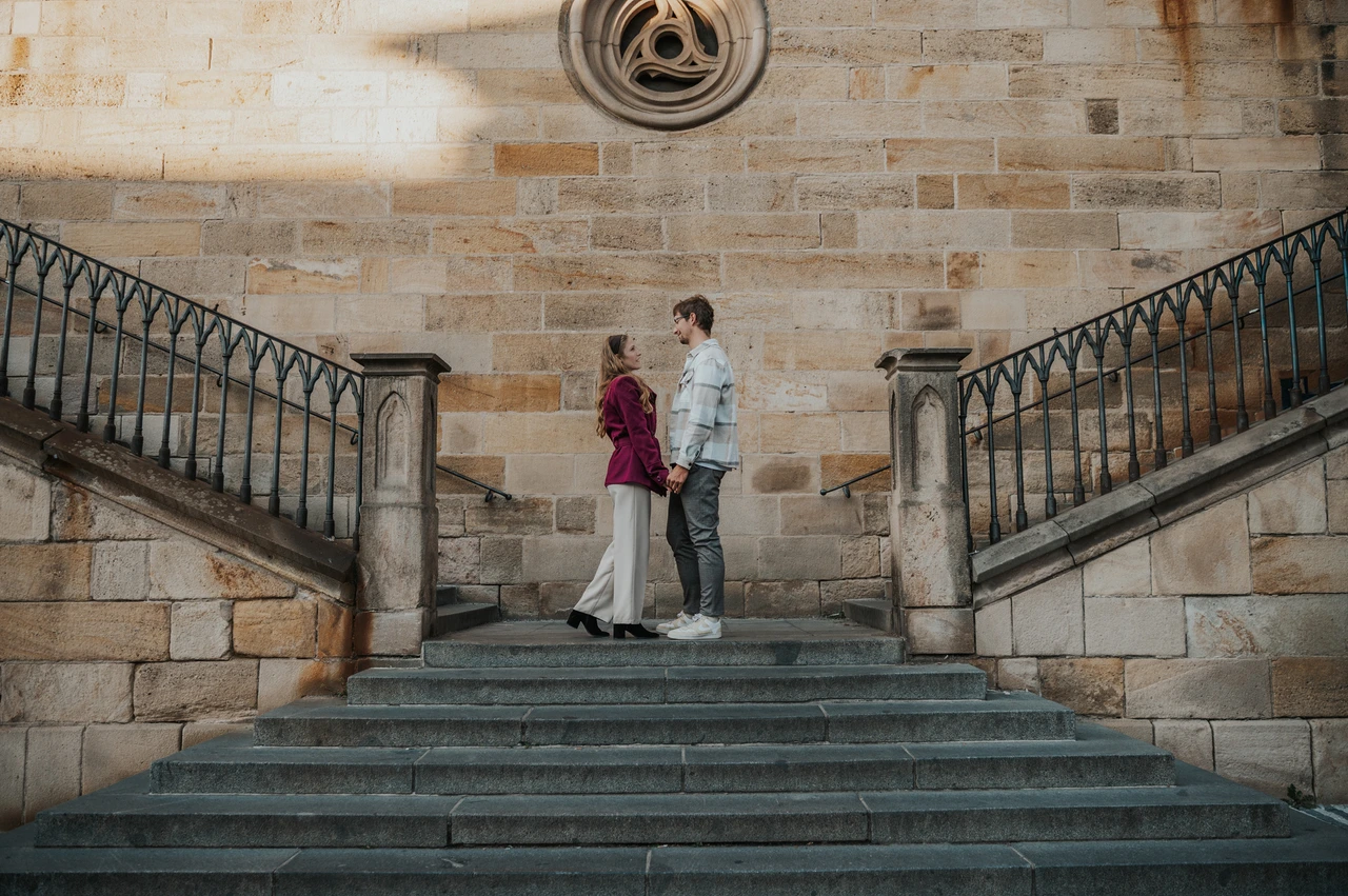 Prague couple photoshoot: couple standing together on the stone Kampa staircase. Couple standing together on the stone Kampa staircase during a couple photoshoot in Prague.