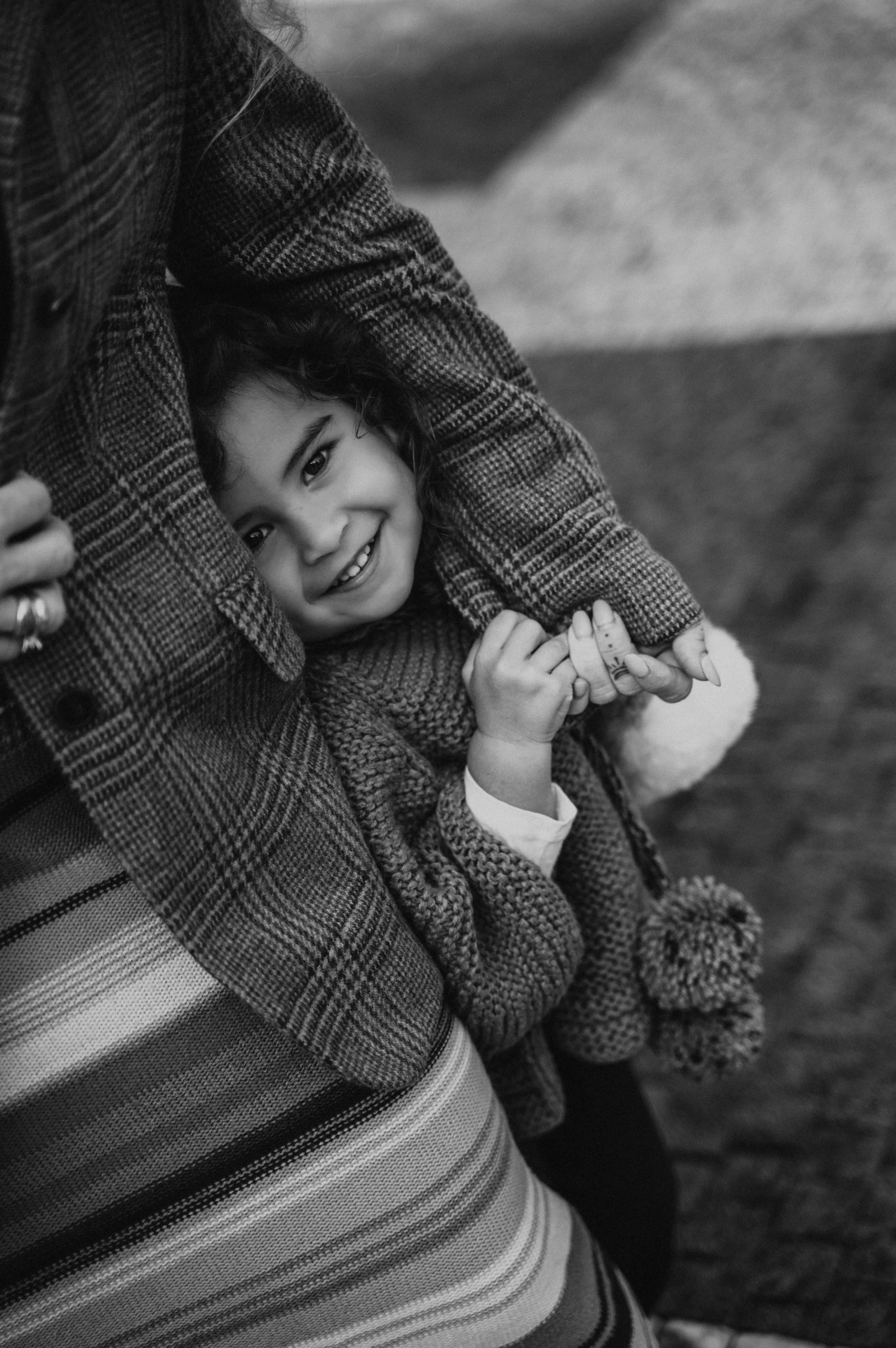 Black and white close detail of the little girl holding her mother’s hand during a mother and daughter family photoshoot in Prague.