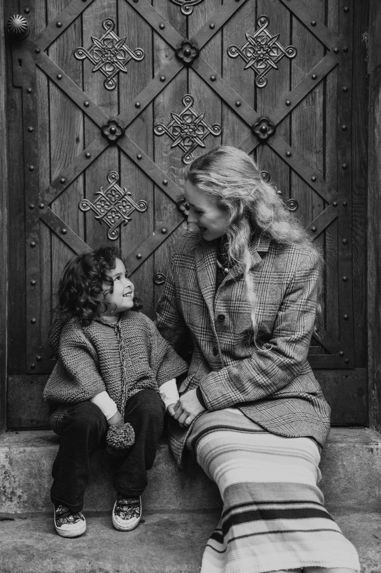 Black and white portrait of mother and daughter in the doorway during a mother and daughter family photoshoot in Prague.