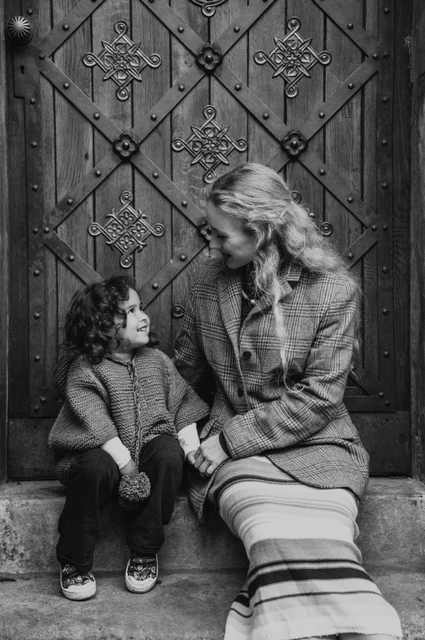 Prague family photoshoot: black and white portrait of mother and daughter in the doorway. Black and white portrait of mother and daughter in the doorway during a mother and daughter family photoshoot in Prague.