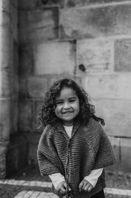 Prague family photoshoot: black and white portrait of the little girl smiling. Black and white portrait of the little girl smiling during a mother and daughter family photoshoot in Prague.