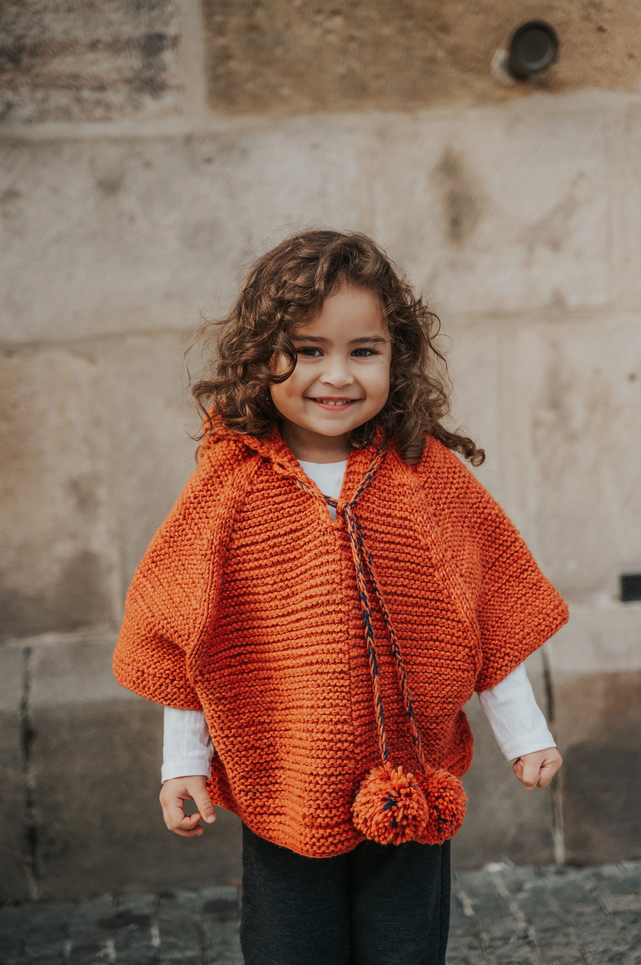 Close portrait of the little girl smiling in Old Town during a mother and daughter family photoshoot in Prague.