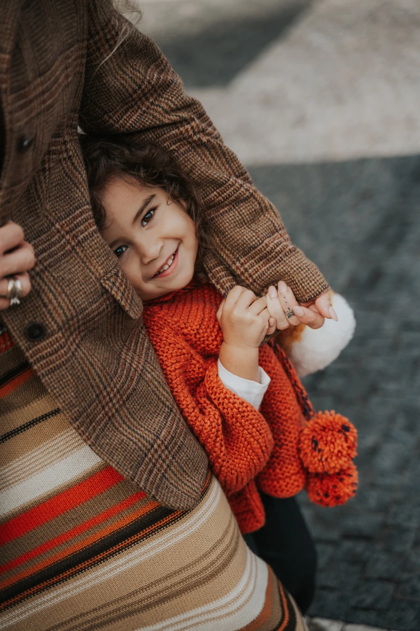 Prague family photoshoot: little girl cuddling against her mother and holding her hand. Little girl cuddling against her mother and holding her hand during a mother and daughter family photoshoot in Prague.