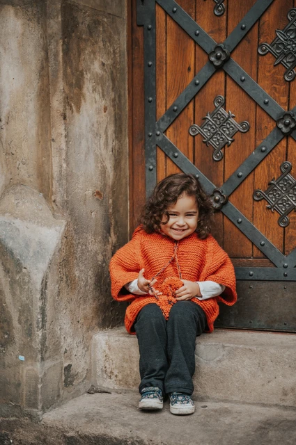 Prague family photoshoot: little girl smiling on the stone doorstep. Little girl smiling on the stone doorstep during a mother and daughter family photoshoot in Prague.