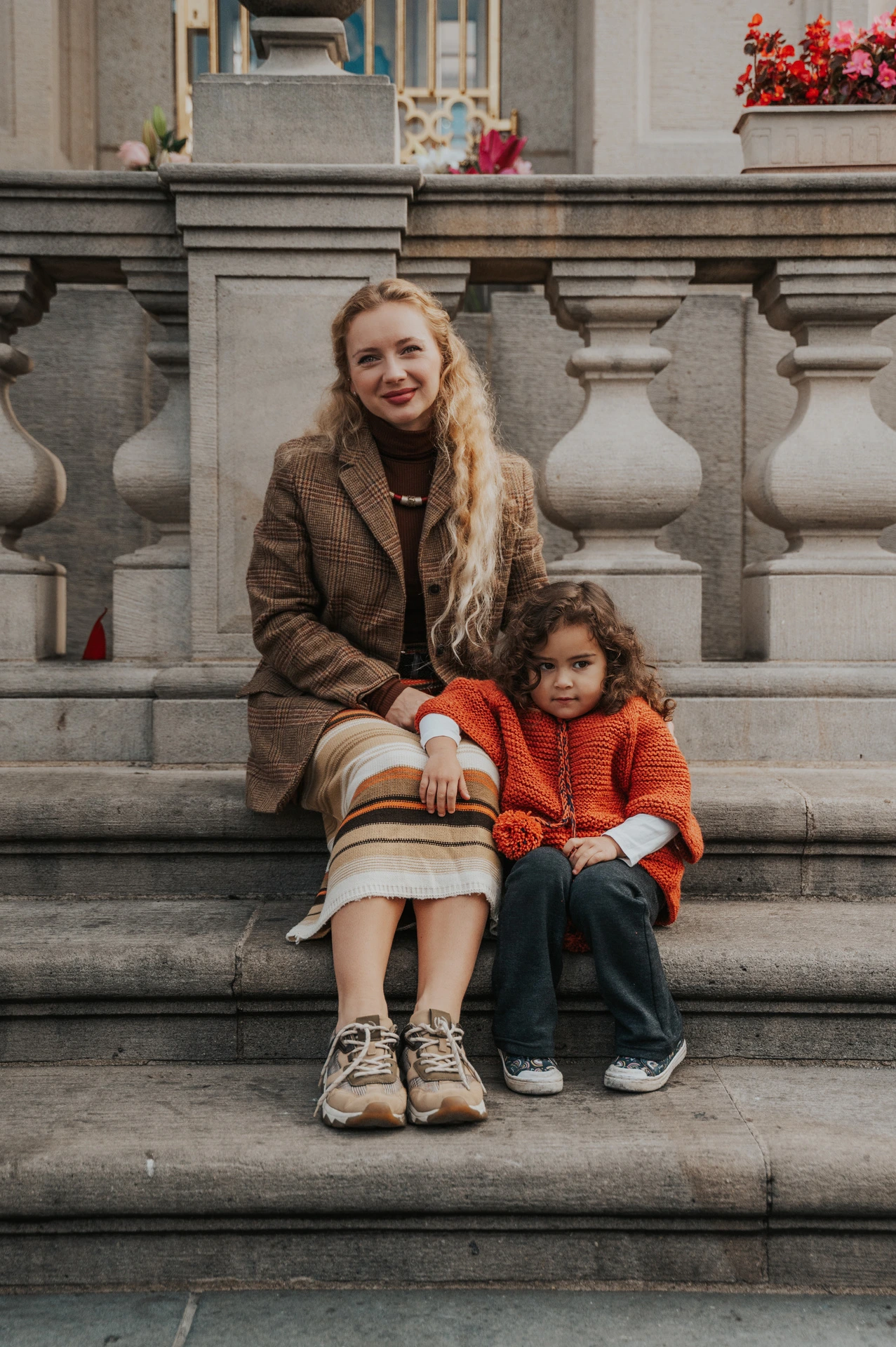 Mother and daughter sitting together on stone steps during a mother and daughter family photoshoot in Prague.