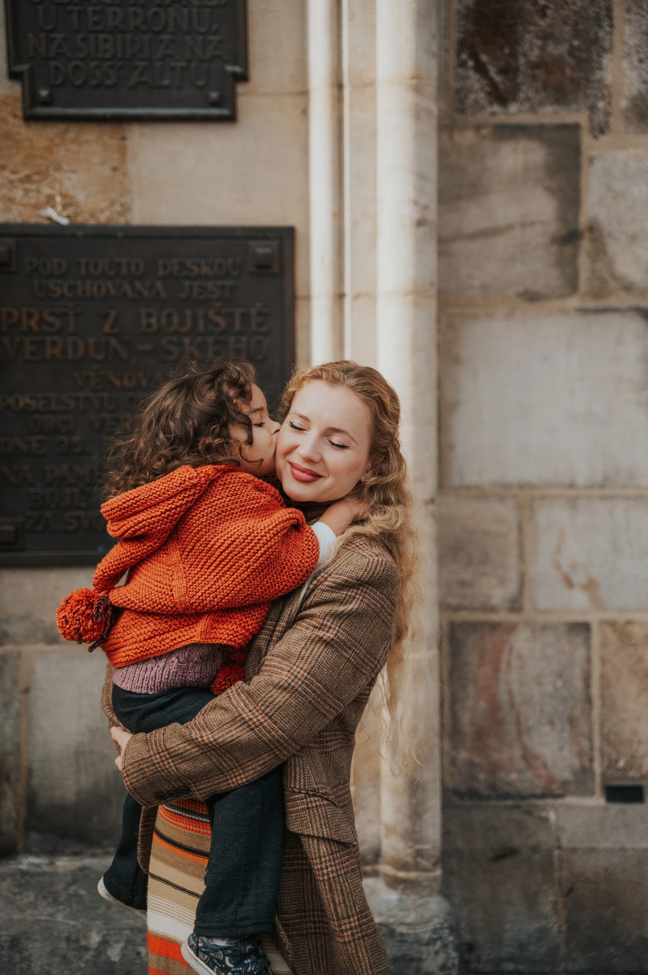 Mother lifting her daughter into an embrace during a mother and daughter family photoshoot in Prague.
