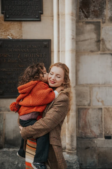 Prague family photoshoot: mother lifting her daughter into an embrace. Mother lifting her daughter into an embrace during a mother and daughter family photoshoot in Prague.