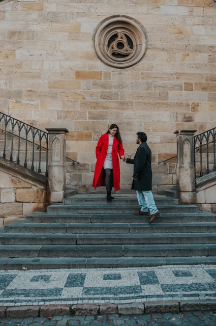 Prague couple photoshoot: couple reaching for each other on the Kampa stairs. Couple reaching for each other on the Kampa stairs during a couple photoshoot in Prague.