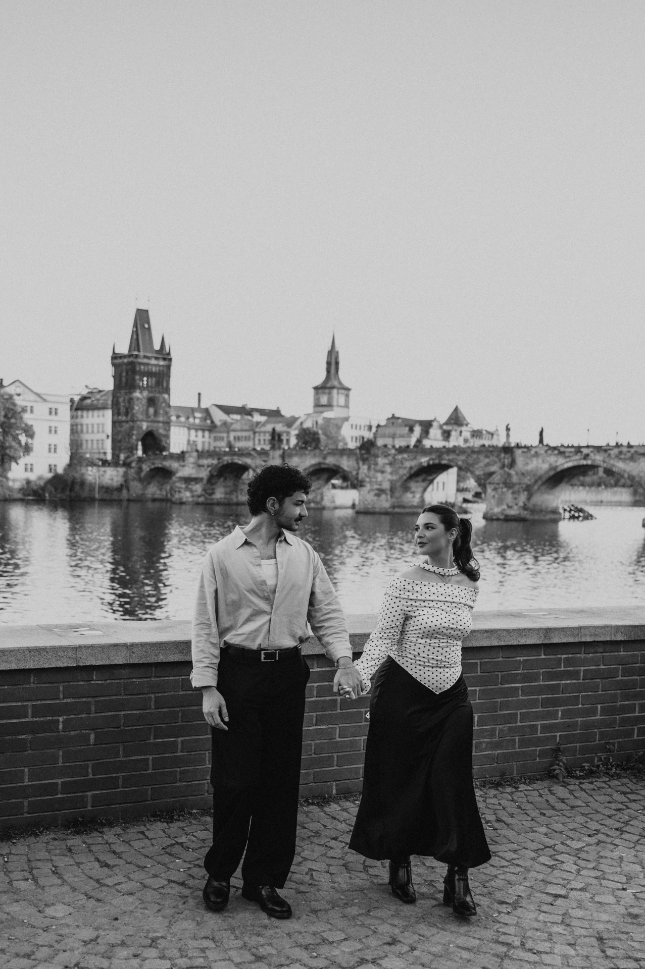 Black and white walk beside the Vltava during a couple photoshoot in Prague.