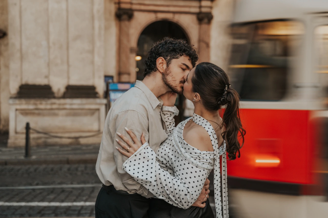 Prague couple photoshoot: close portrait of a kiss beside a passing tram. Close portrait of a kiss beside a passing tram during a couple photoshoot in Prague.