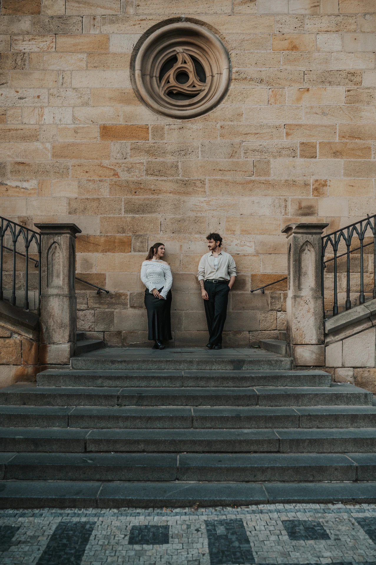 Couple holding hands on the broad Kampa staircase during a couple photoshoot in Prague.