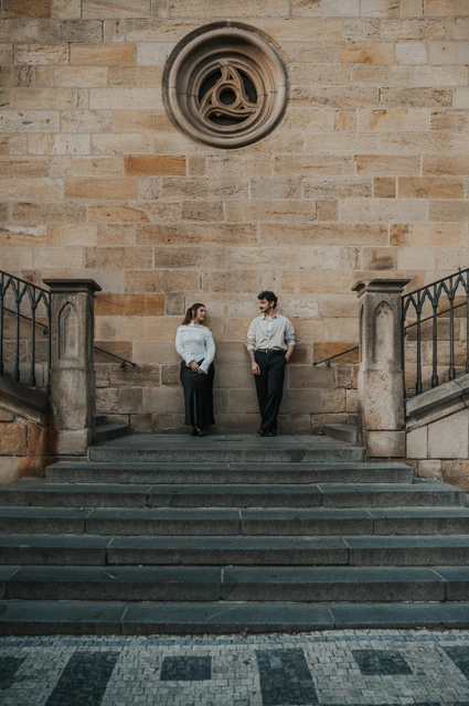 Couple holding hands on the broad Kampa staircase during a couple photoshoot in Prague.
