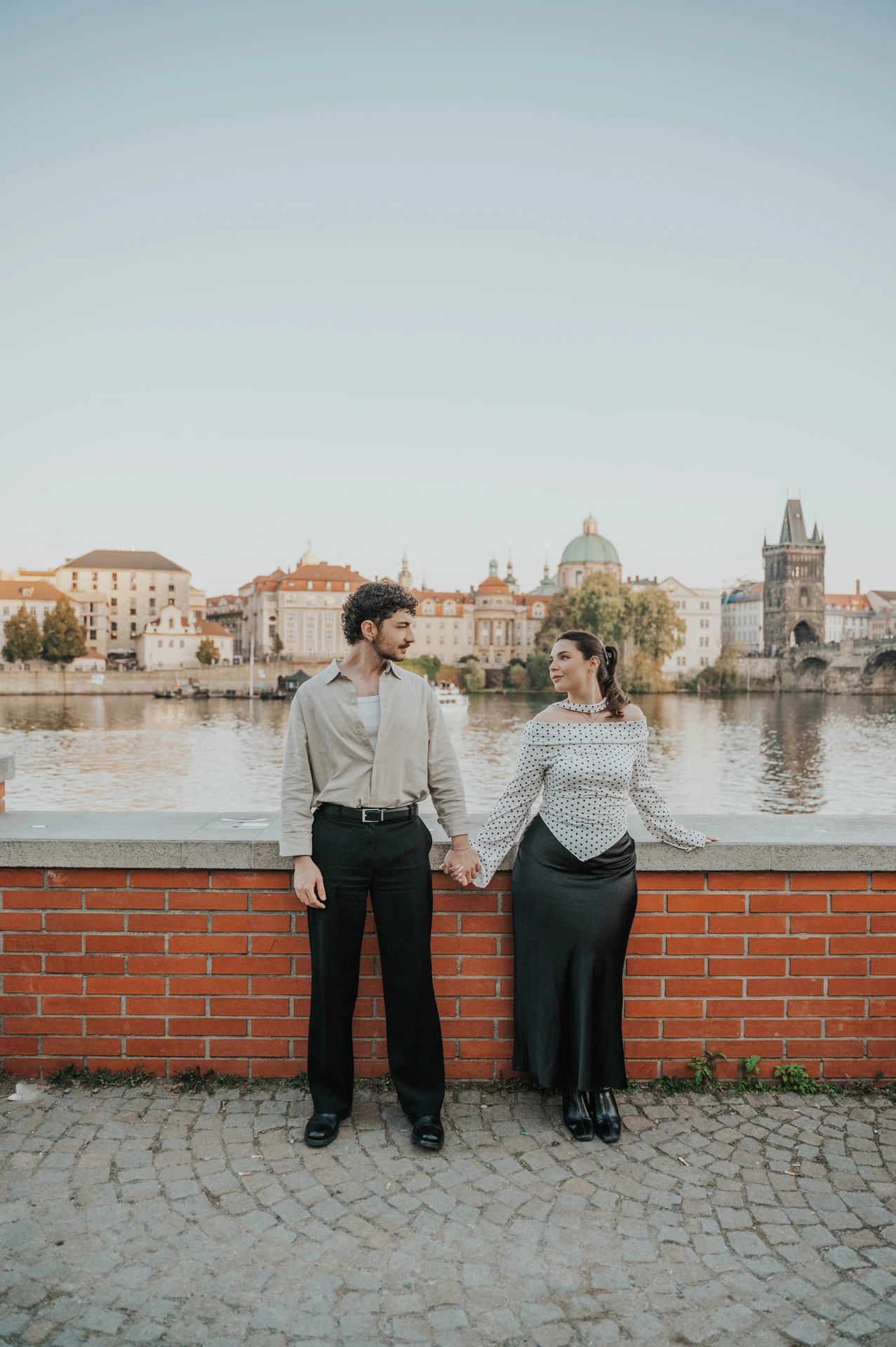 Couple standing close beside the Vltava wall during a couple photoshoot in Prague.