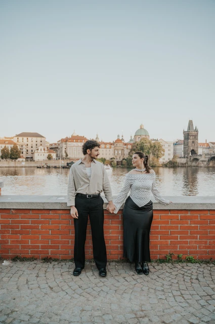 Prague couple photoshoot: couple standing close beside the Vltava wall. Couple standing close beside the Vltava wall during a couple photoshoot in Prague.